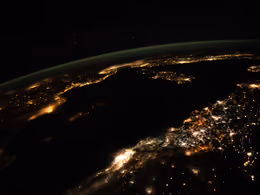 City lights along the coasts of north Africa and southern Europe at night, seen from orbit