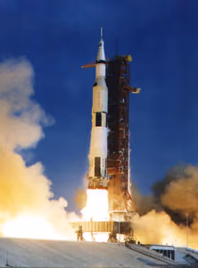 Apollo 11 Saturn V rocket clearing the launch tower in a burst of fire