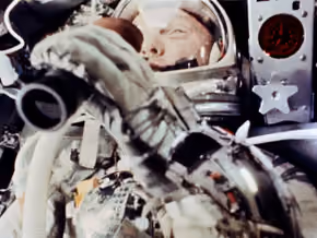 John Glenn in his spacesuit inside the Friendship 7 capsule, filmed by an onboard camera